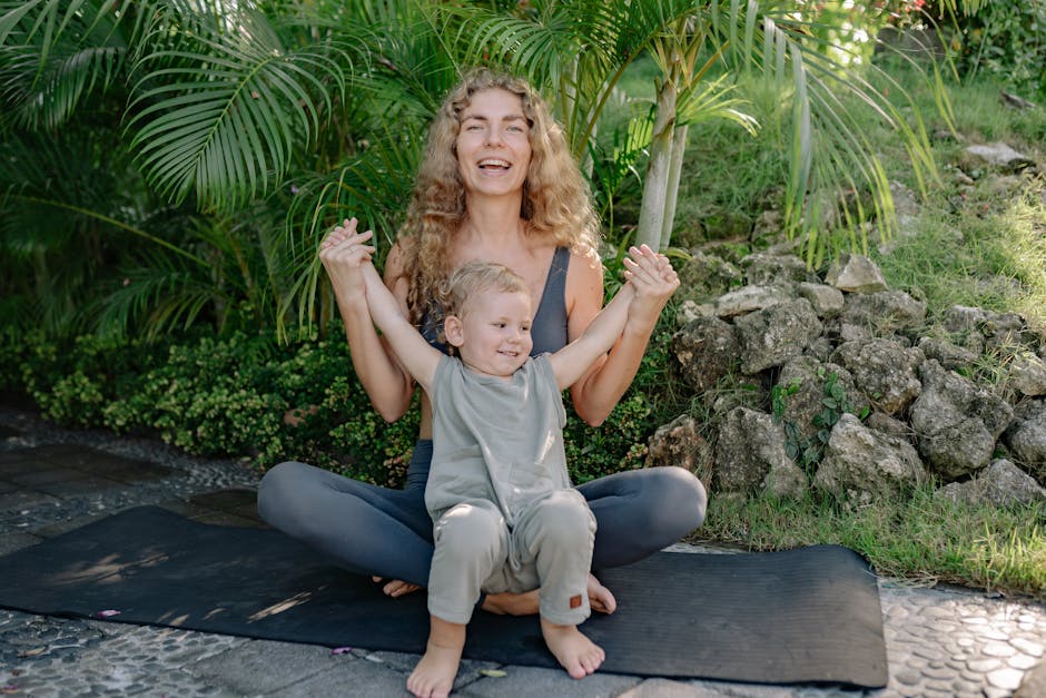 A smiling woman in yoga attire sitting comfortably on her mat in a park